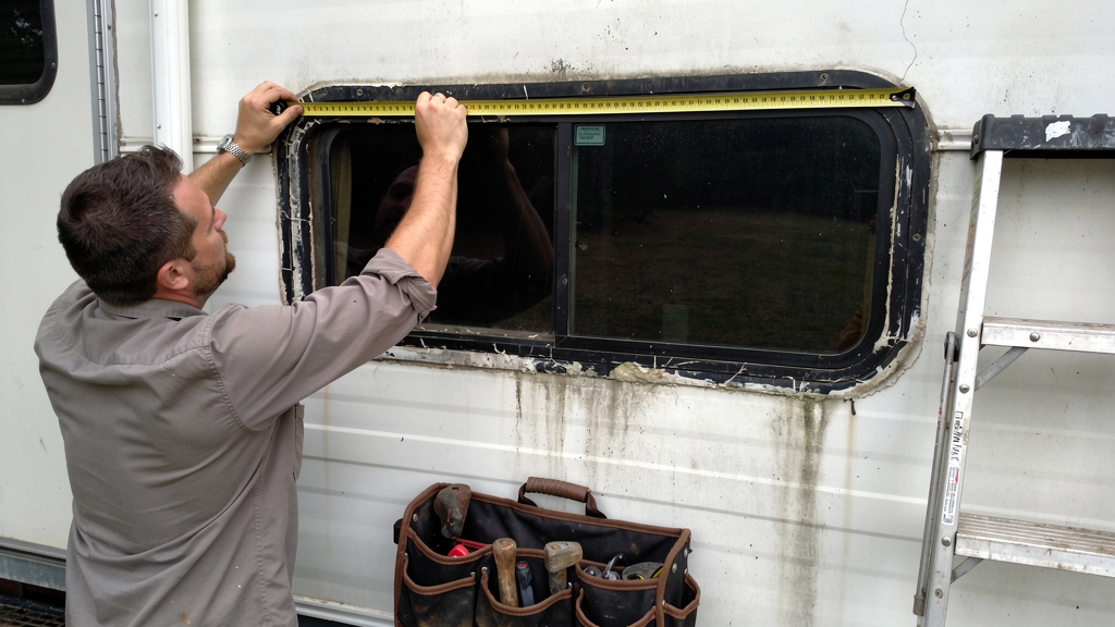 RV side window and frame being measured for replacement